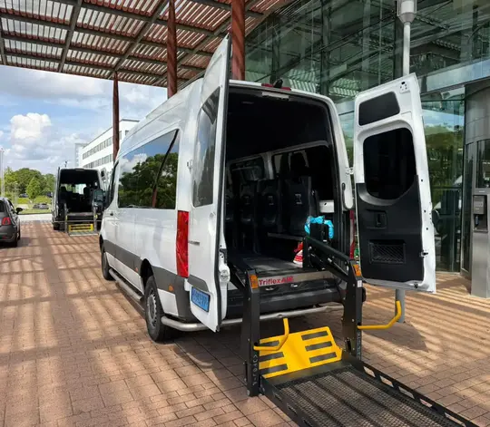 Professionele rolstoeltaxi chauffeur helpt klant in Zandvoort